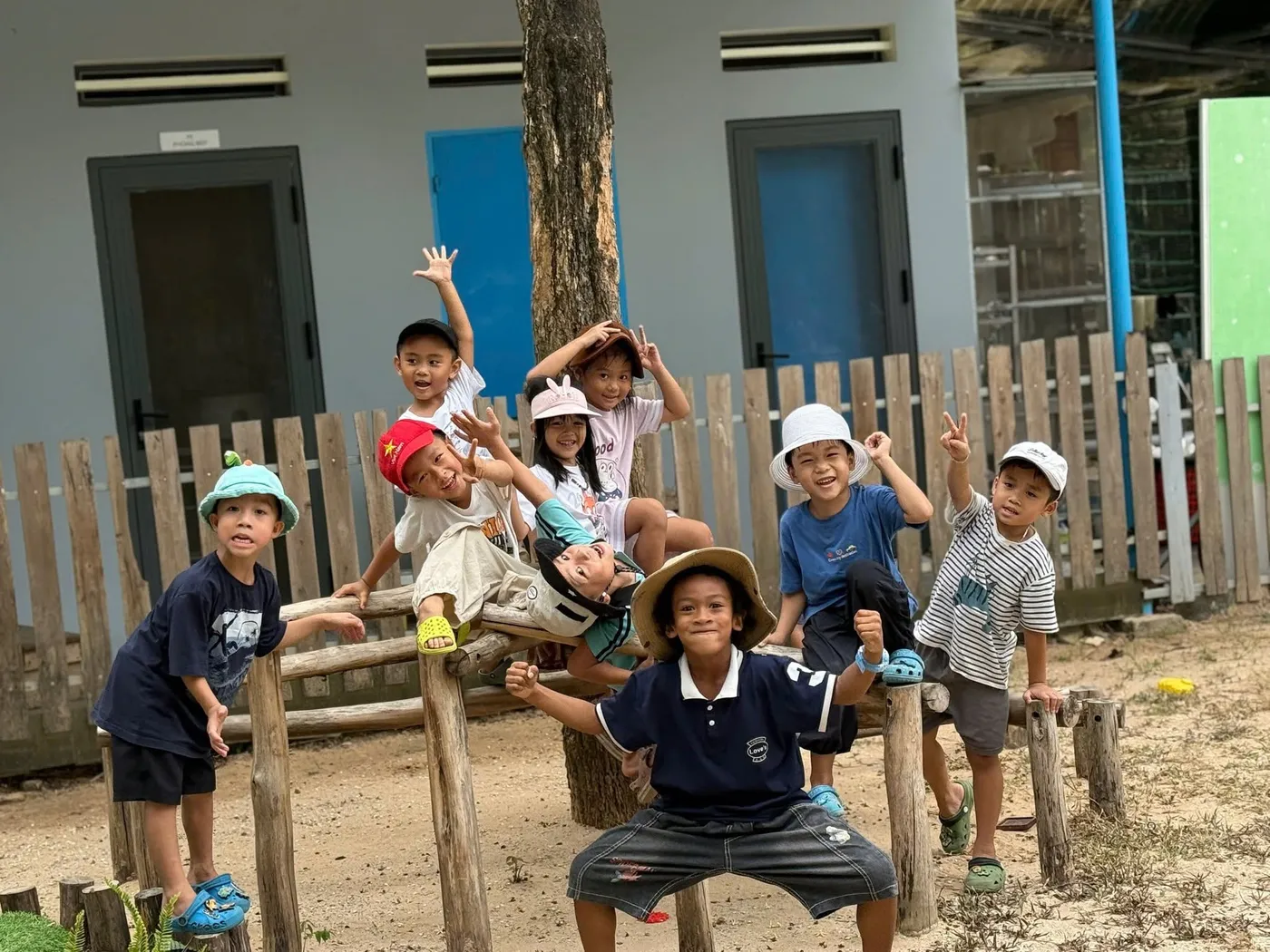 Nhóm bạn rạng rỡ tạo dáng trên sân chơi gỗ của trường